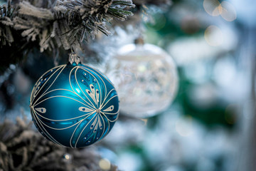 Christmas background. Detail view of blue and silver baubles and festive decorations hanging on a...