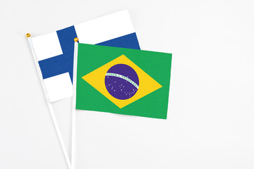 Brazil and Finland stick flags on white background. High quality fabric, miniature national flag. Peaceful global concept.White floor for copy space.