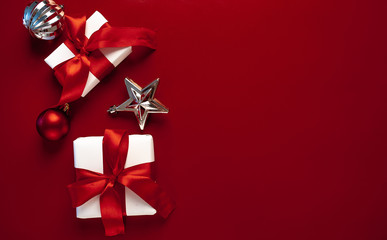 Christmas card with gift boxes on a red background. White Christmas gift boxes on a red background. Top view with place for your congratulations.