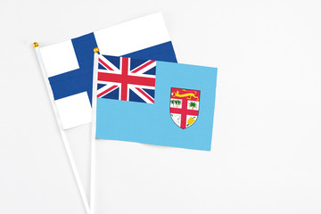 Fiji and Finland stick flags on white background. High quality fabric, miniature national flag. Peaceful global concept.White floor for copy space.