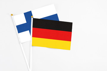 Germany and Finland stick flags on white background. High quality fabric, miniature national flag. Peaceful global concept.White floor for copy space.