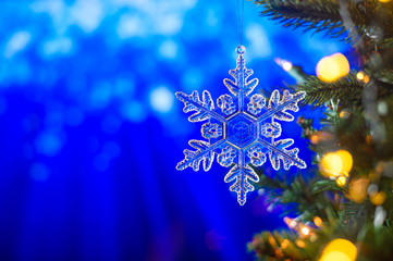 Fototapeta na wymiar Christmas and background.Toy in the form of a transparent star on a Christmas tree, background for a card, dark blue bokeh background, Greeting card for a congratulation for design. Inscription