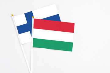 Hungary and Finland stick flags on white background. High quality fabric, miniature national flag. Peaceful global concept.White floor for copy space.