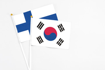South Korea and Finland stick flags on white background. High quality fabric, miniature national flag. Peaceful global concept.White floor for copy space.