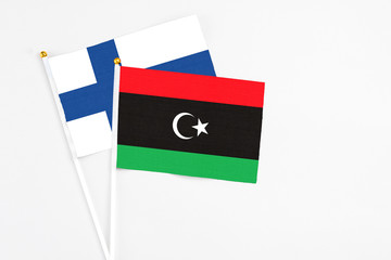 Libya and Finland stick flags on white background. High quality fabric, miniature national flag. Peaceful global concept.White floor for copy space.