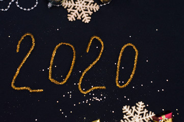 New Year. Inscription 2020 on a black background with Christmas decorations