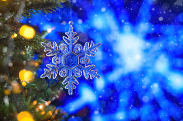 Fototapeta na wymiar Christmas and background.Toy in the form of a transparent star on a Christmas tree, background for a card, dark blue bokeh background, Greeting card for a congratulation