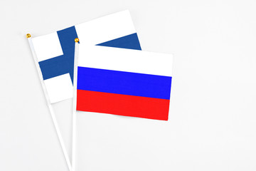 Russia and Finland stick flags on white background. High quality fabric, miniature national flag. Peaceful global concept.White floor for copy space.