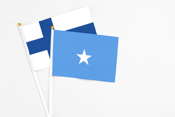 Somalia and Finland stick flags on white background. High quality fabric, miniature national flag. Peaceful global concept.White floor for copy space.