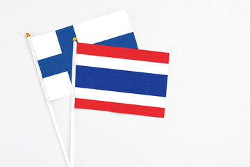 Thailand and Finland stick flags on white background. High quality fabric, miniature national flag. Peaceful global concept.White floor for copy space.