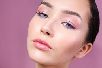 Fototapeta premium Portrait of young beautiful woman with perfectly clean face skin wearing professional make up. Female with long black hair. Close up, copy space background.