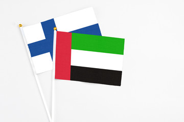 United Arab Emirates and Finland stick flags on white background. High quality fabric, miniature national flag. Peaceful global concept.White floor for copy space.