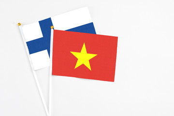 Vietnam and Finland stick flags on white background. High quality fabric, miniature national flag. Peaceful global concept.White floor for copy space.