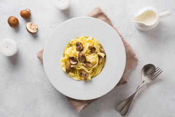 Spaghetti reginelle pasta with mushrooms on white. Tasty healthy dinner. View from above.