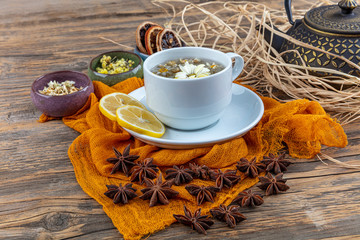 Chamomile tea in cast teapot. Chamomile tea cup, antique chinese cast iron teapot, lemon and star...