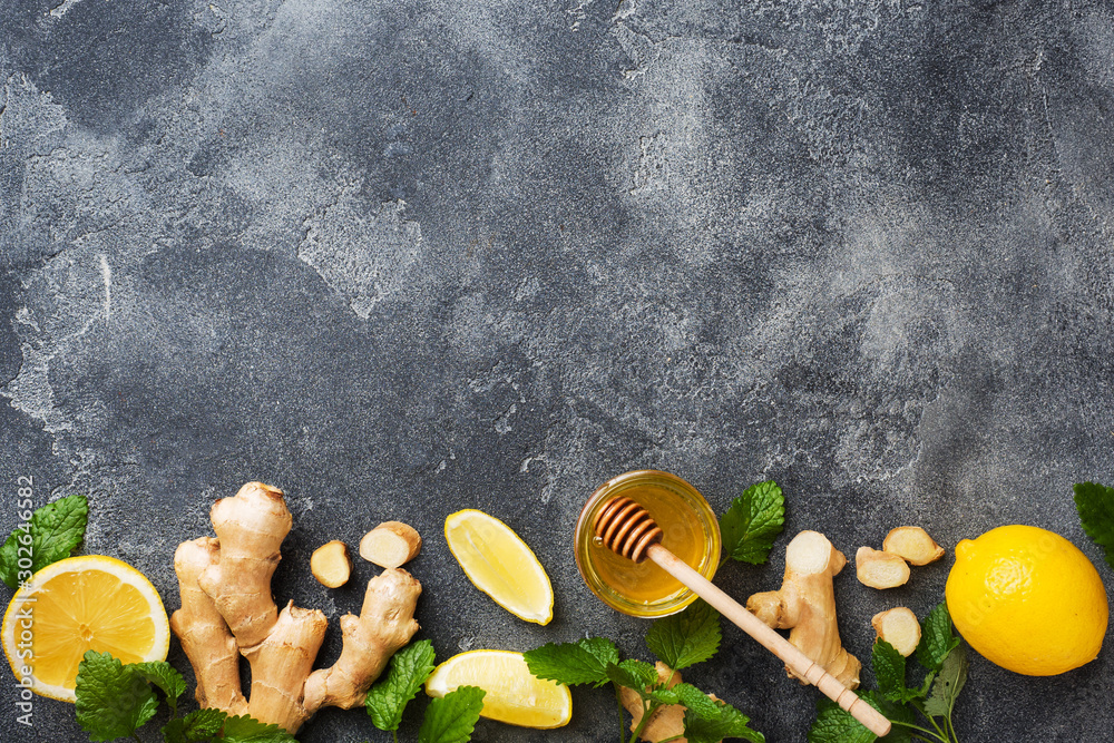 Wall mural lemon honey and ginger root mint on dark grey background with copy space. ingredients for a tonic vi