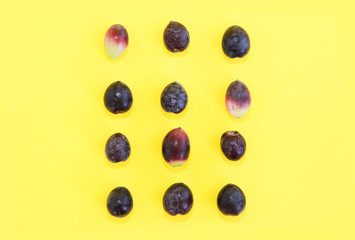 natural fresh black olives on a yellow background