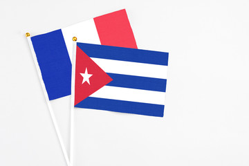 Cuba and France stick flags on white background. High quality fabric, miniature national flag. Peaceful global concept.White floor for copy space.