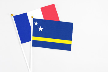 Curacao and France stick flags on white background. High quality fabric, miniature national flag. Peaceful global concept.White floor for copy space.