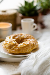 Simple real breakfast with coffee and custard cake on white plate