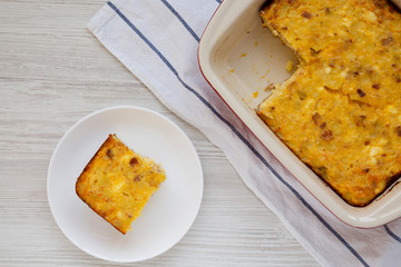 Homemade Cheesy Amish Breakfast Casserole on a white wooden background, top view. Flat lay, overhead, from above.