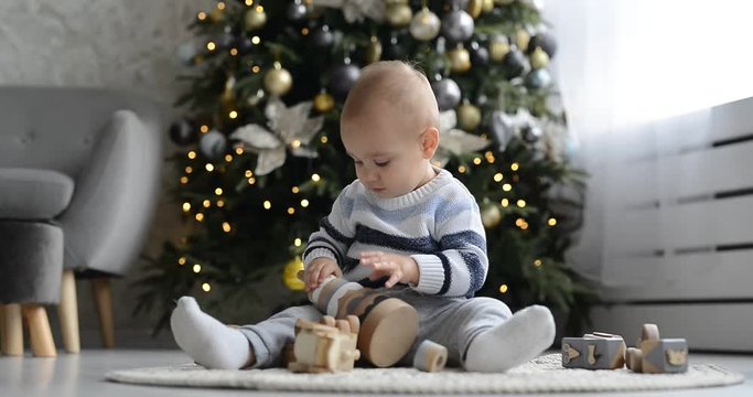 Cute little boy is playing with toy wooden train, toy car, pyramid and cubes, learning development concept. Development of kids fine motor skills, imagination and logical thinking