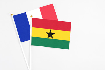 Ghana and France stick flags on white background. High quality fabric, miniature national flag. Peaceful global concept.White floor for copy space.