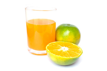 100% of fresh Orange juice in glass with Green oranges and sliced i