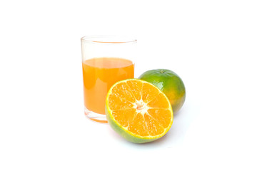 100% of fresh Orange juice in glass with Green oranges and sliced i
