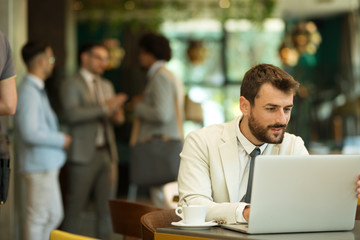 Young freelancer sits drinking coffee