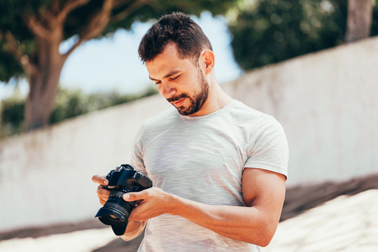 Young man with DSLR camera in city