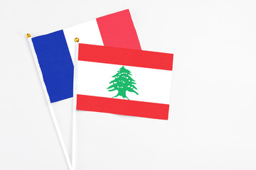 Lebanon and France stick flags on white background. High quality fabric, miniature national flag. Peaceful global concept.White floor for copy space.