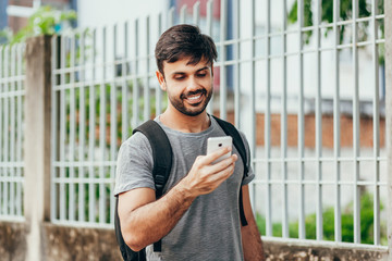 People, technology, travel and tourism - man with smartphone and bag on city street