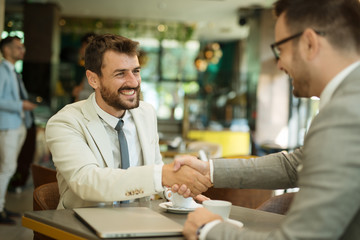 Obraz premium Businessmen shaking hands after meeting in a cafe
