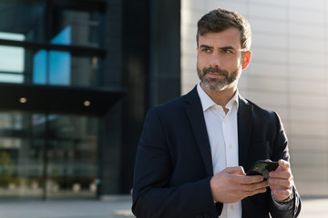 Empresario con smartphone en distrito financiero