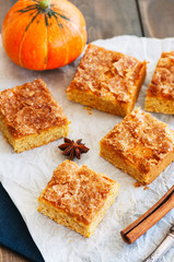 Pumpkin cornmeal bars on a wooden background.