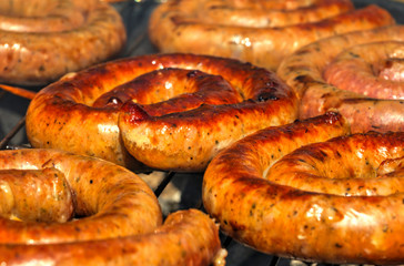 Grilling delicious sausages on barbecue close up view