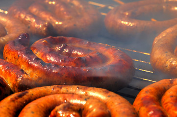 Grilling delicious sausages on barbecue close up view