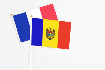 Moldova and France stick flags on white background. High quality fabric, miniature national flag. Peaceful global concept.White floor for copy space.