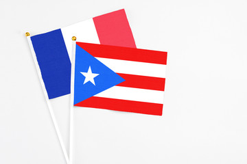 Puerto Rico and France stick flags on white background. High quality fabric, miniature national flag. Peaceful global concept.White floor for copy space.