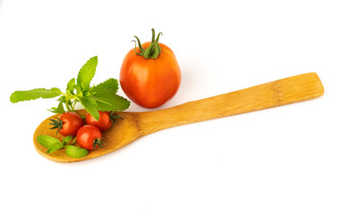 organic cherry Small cherry tomatoes on a wooden spoon on a white backgroundtomatoes