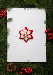 Fototapeta na wymiar Creative layout made of Christmas tree branches with paper card note and snowflake ornament. Nature New Year concept