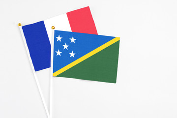 Solomon Islands and France stick flags on white background. High quality fabric, miniature national...