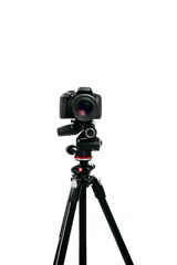 Photo camera with lens on the tripod. Studio shot on white isolate background