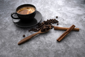 Hot coffee and coffee beans on a concrete background
