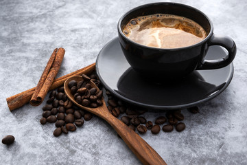 Obraz na płótnie Canvas Hot coffee and coffee beans on a concrete background