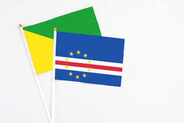 Cape Verde and French Guiana stick flags on white background. High quality fabric, miniature national flag. Peaceful global concept.White floor for copy space.