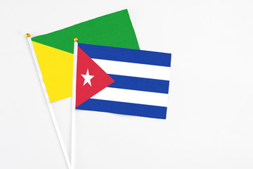 Cuba and French Guiana stick flags on white background. High quality fabric, miniature national flag. Peaceful global concept.White floor for copy space.