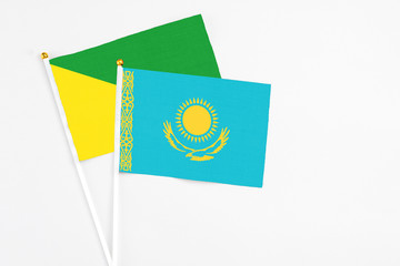 Kazakhstan and French Guiana stick flags on white background. High quality fabric, miniature national flag. Peaceful global concept.White floor for copy space.