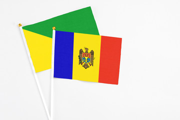 Moldova and French Guiana stick flags on white background. High quality fabric, miniature national flag. Peaceful global concept.White floor for copy space.